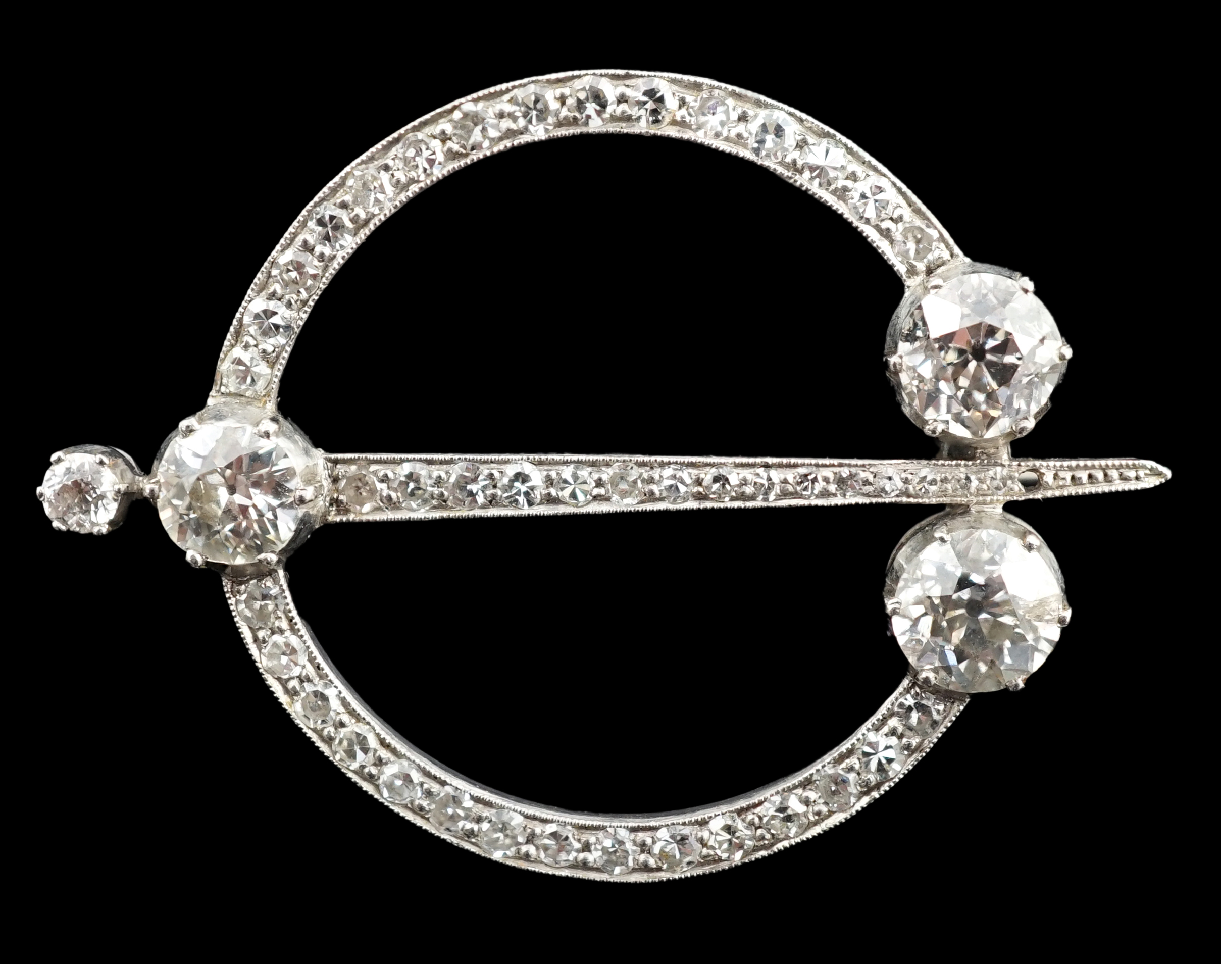 A 1920's platinum or white gold, diamond cluster set openwork 'dagger and circle' brooch